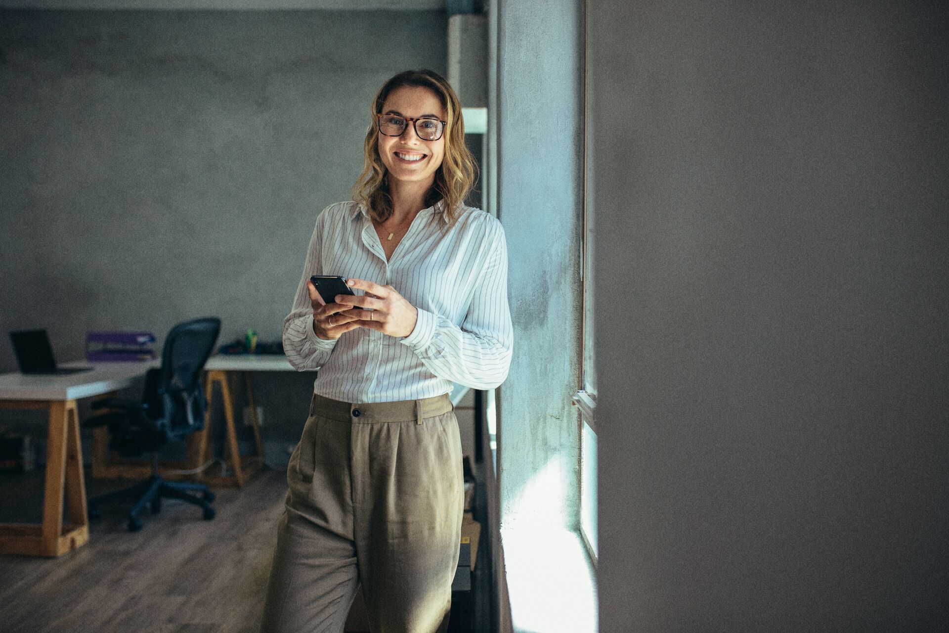 Smiling woman holding her phone in her hands.